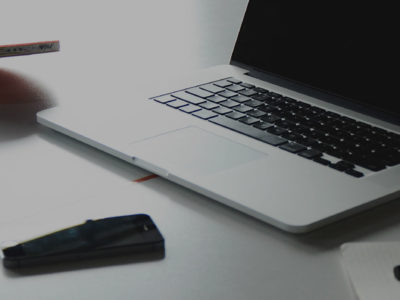 laptop beside a ping pong ball and racket 