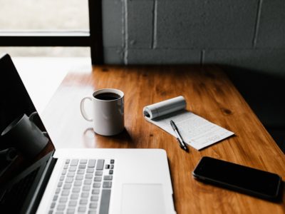 laptop, coffee and a paper on top of the table